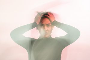 blurry stressed woman grabs head